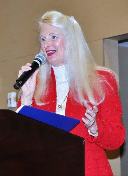 Snowden McFall speaking at a podium during a business event, delivering an energized Fired Up style keynote on leadership and motivation.