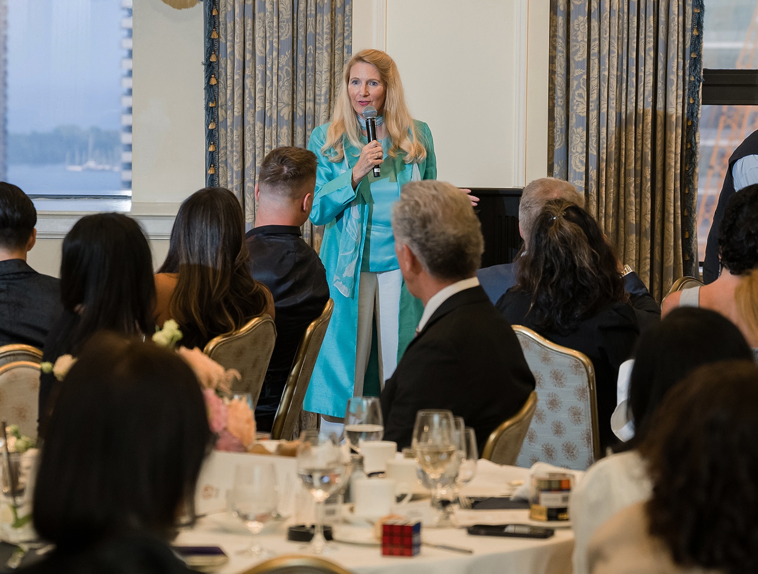 Snowden McFall presenting a resilience focused keynote at a formal corporate event, speaking to business leaders and professionals.